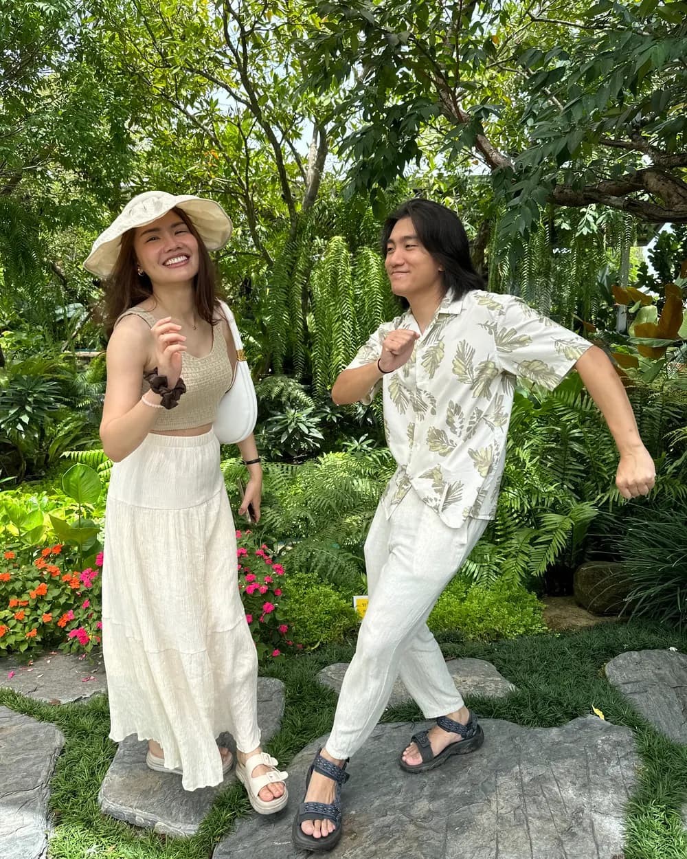 Jam and Tony larking about in cream linen among ferns and bougainvillea at a garden cafe in Khao Yai